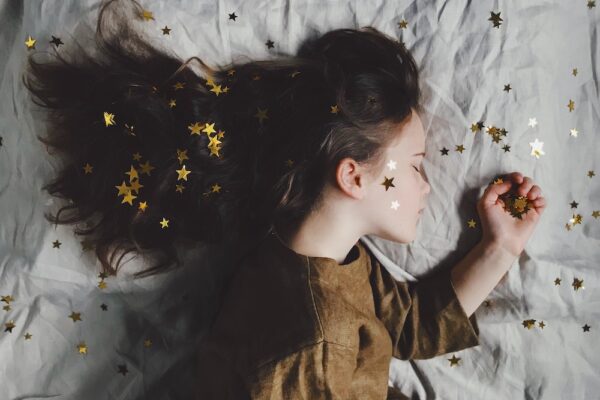 a young girl sleeping with gold star confetti everywhere
