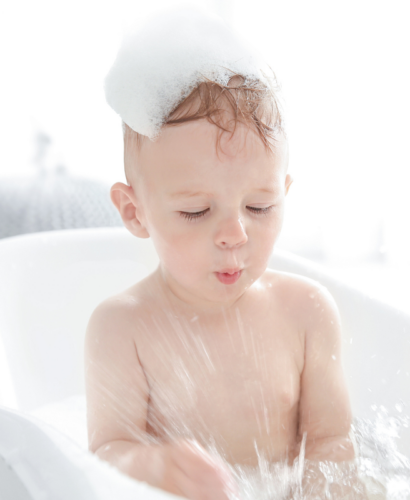 a toddler playing in the bath tub with bubbles
