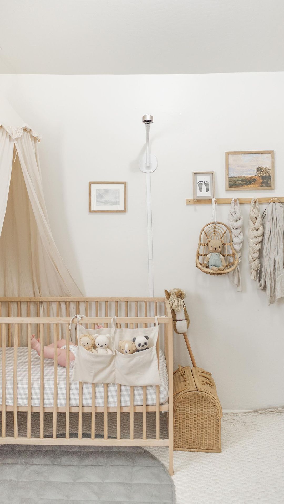 A nursery with a white and beige palette and a minimalist boho decor style