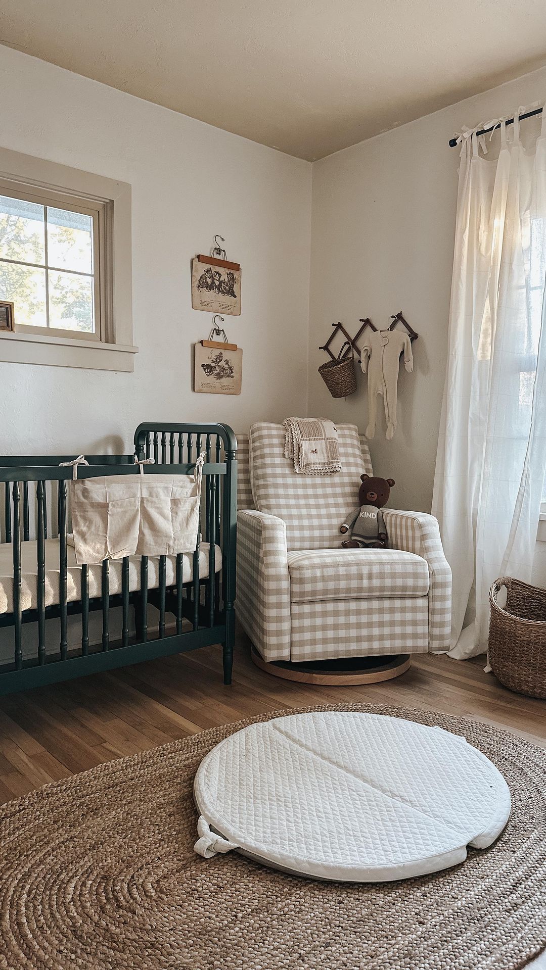 A baby boy nursery with a forest green crib, a plaid glider, and other vintage-style decor