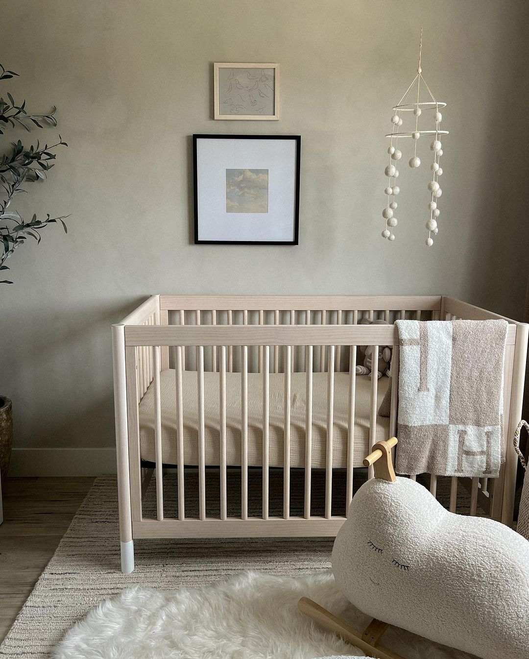 A baby boy nursery room with a brushed grey wall and minimal neutral decor