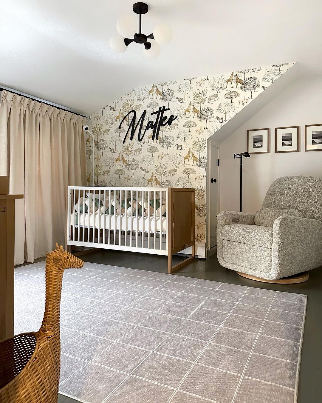 A baby boy nursery room with safari animal wallpaper, and beige and grey tones throughout