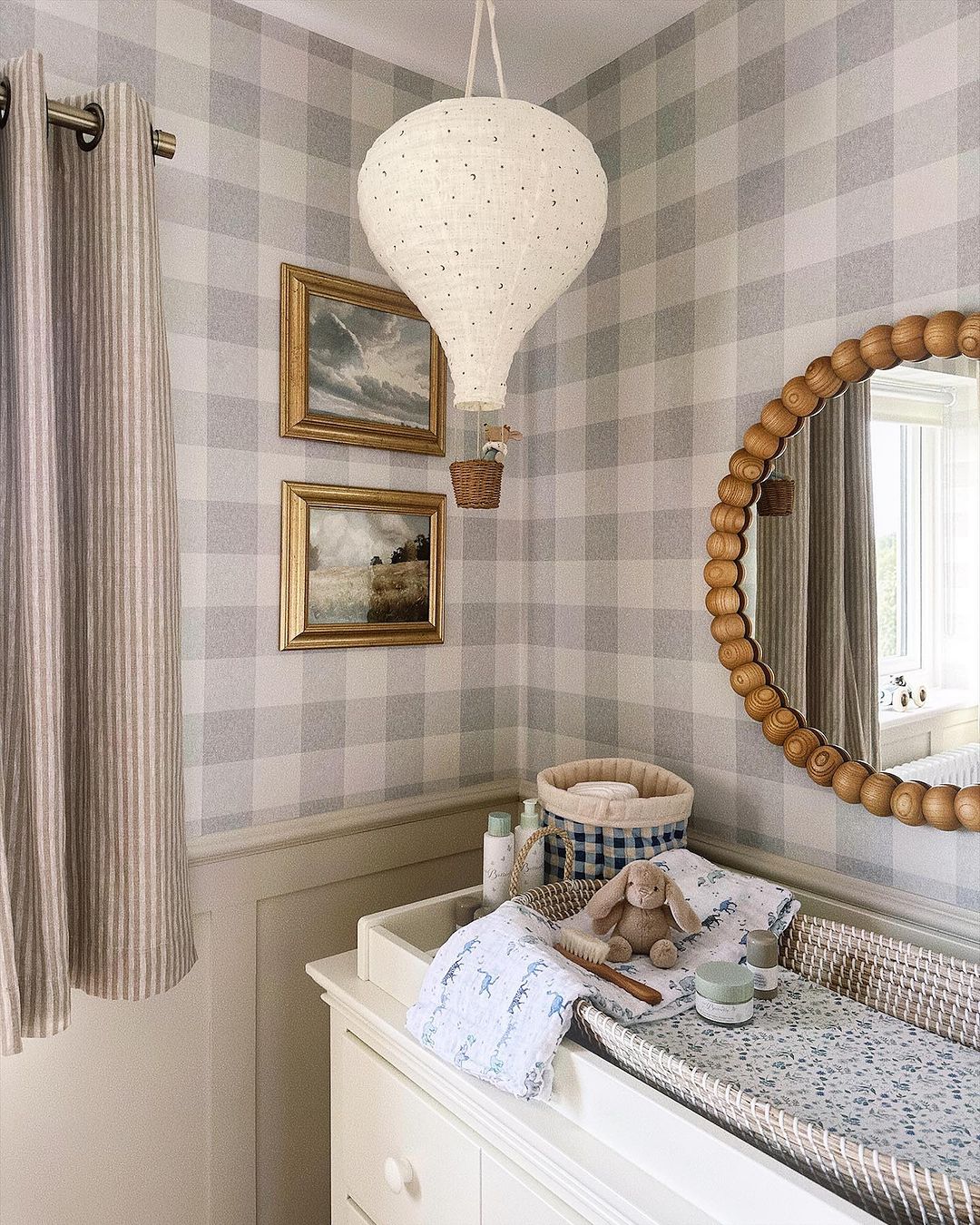 A baby boy nursery room with grey and white gingham wallpaper, a hot air balloon, and vintage touches
