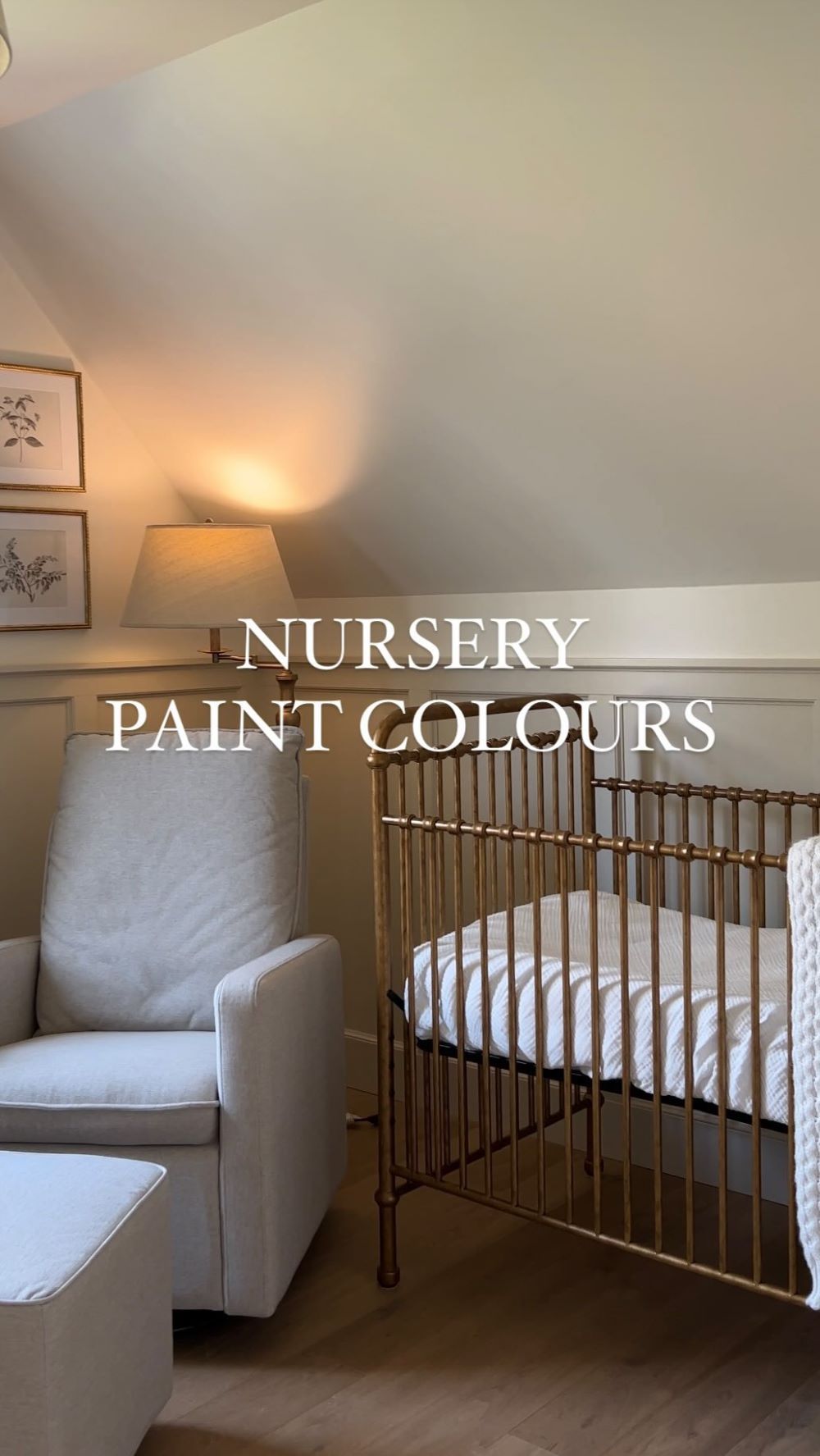 A nursery with soft white walls, a brass-toned crib, and classic decor pieces