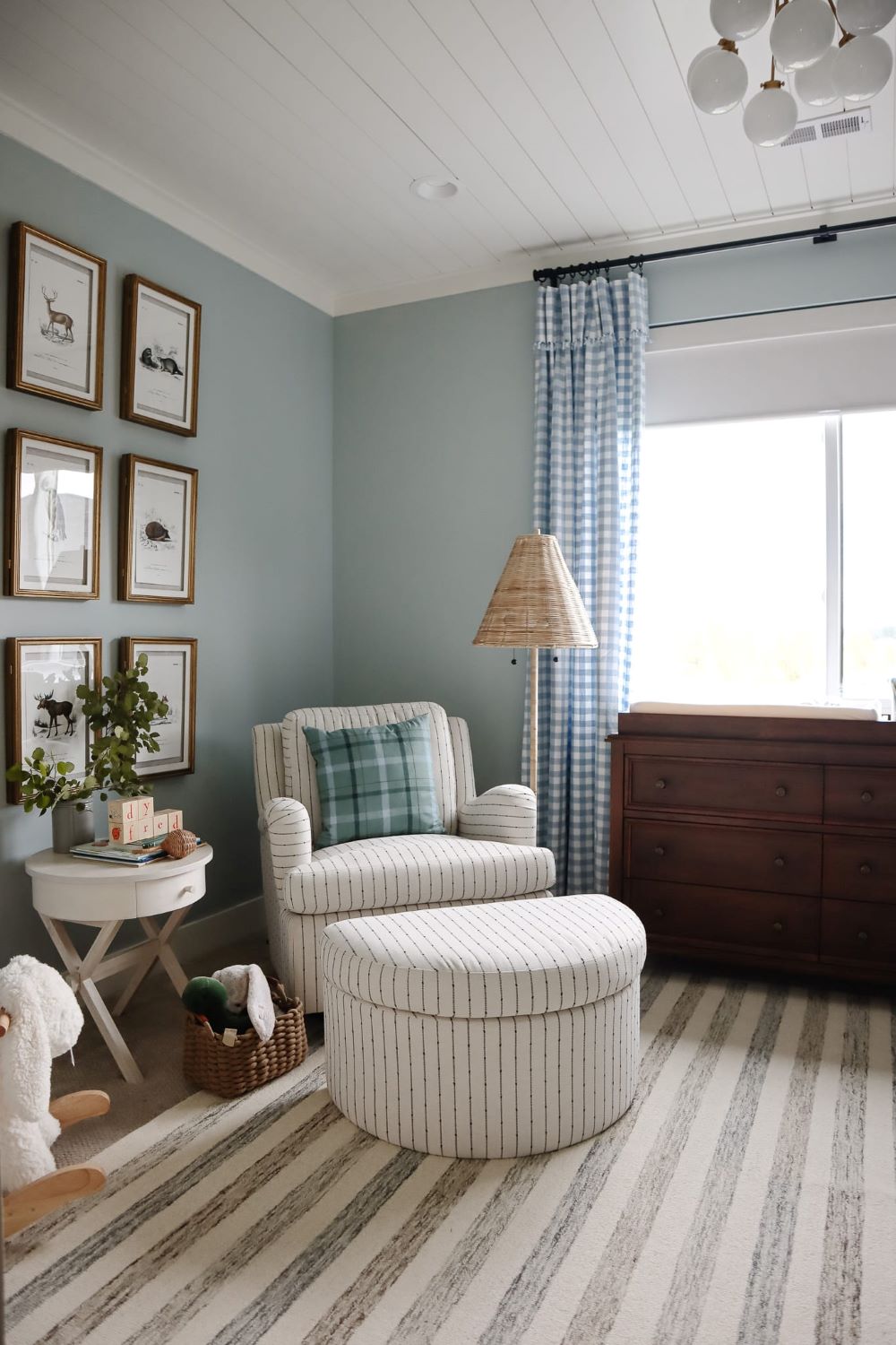 A nursery with soft blue walls and classic decor pieces