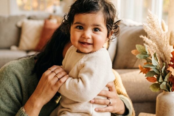 Baby in a living room corner bathed in golden autumn afternoon light — Autumn Baby Names for a Fall-Born Little One