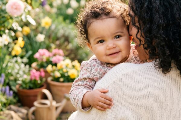 Baby Girl in a sunlit spring garden with blooming flowers and fresh greenery — 200+ Baby Names That Mean Life — Vibrant, Vital, and Full of Energy