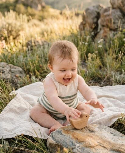 Baby Girl in an open meadow with natural rock formations and tall grasses — 200+ Baby Names That Mean Strength — Powerful Picks for Boys and Girls