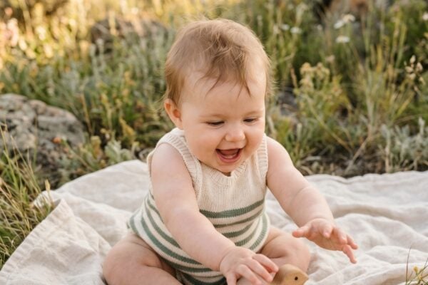 Baby Girl in an open meadow with natural rock formations and tall grasses — 200+ Baby Names That Mean Strength — Powerful Picks for Boys and Girls