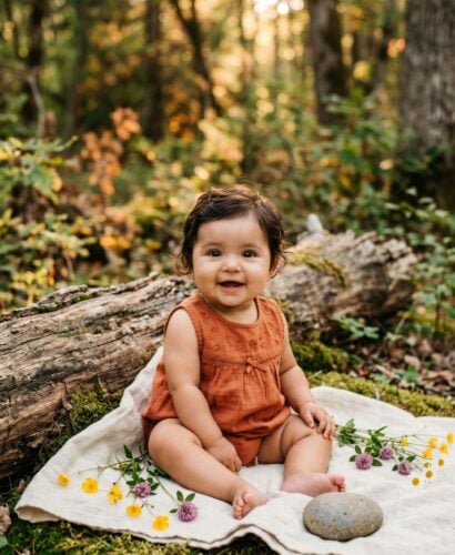 Baby Girl in a sun-dappled forest edge with soft moss and weathered logs — 200+ Baby Names That Mean Warrior — Bold, Brave, and Battle-Ready