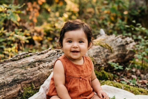 Baby Girl in a sun-dappled forest edge with soft moss and weathered logs — 200+ Baby Names That Mean Warrior — Bold, Brave, and Battle-Ready