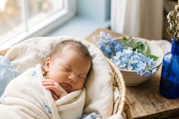 Baby Girl in a soft studio with pale blue backdrop near a window β 200+ Color-Inspired Baby Names From Azure to Indigo