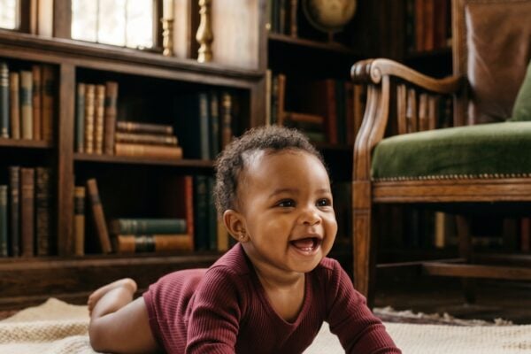 Baby Girl in a home library corner with dark wooden shelves — 200+ Dark Academia Baby Names for the Bookish, Brooding Parent