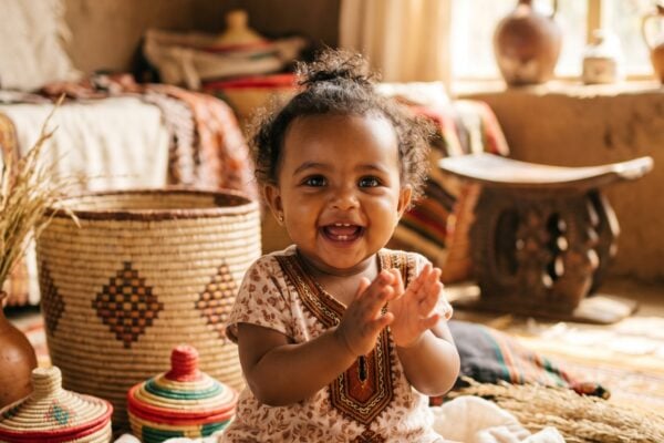Baby in a sunlit room with layered Ethiopian woven textiles and baskets — Ethiopian Baby Names With Powerful Meanings
