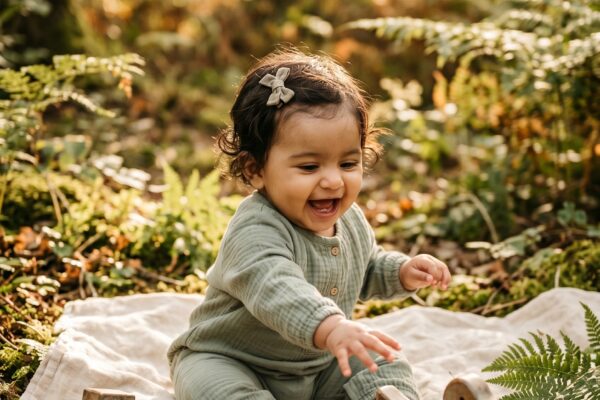 Baby Girl in a sunlit forest clearing with dappled light and natural ground — 200+ Forest Baby Names for Your Little Woodland Wanderer
