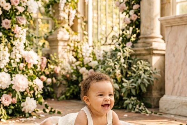 Baby Girl in a bright garden conservatory with classical stone and tumbling flowering vines — 200+ Goddess Names for Girls — Powerful, Mythical, and Wildly Unique