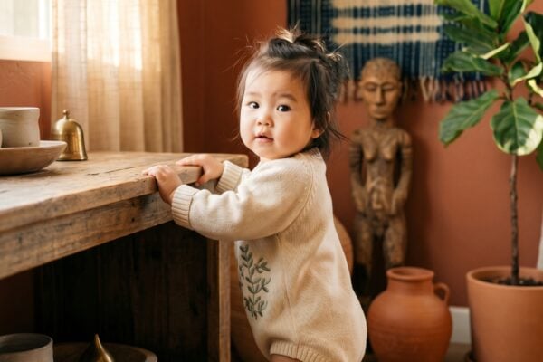 Baby Girl in a sun-lit corner with woven textiles and terracotta-toned walls — 200+ Igbo Baby Names From the Heart of Nigeria