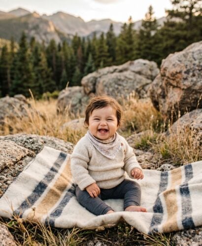 Baby in a rugged mountain foothill with granite boulders and evergreen backdrop — Mountain Baby Names With Granite Strength