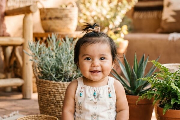 Baby Girl in a sunlit patio with native plants and woven textiles — 200+ Native American Baby Names Honoring Indigenous Heritage