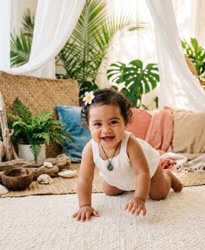 Baby Girl in a sun-warmed coastal corner with flowing fabrics and living greenery — 200+ Polynesian Baby Names Inspired by the Ocean and the Stars