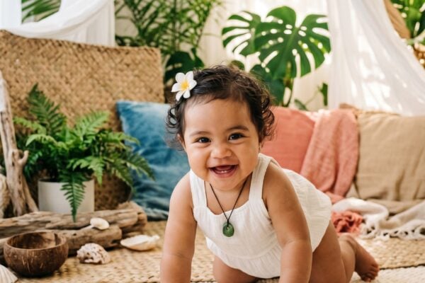 Baby Girl in a sun-warmed coastal corner with flowing fabrics and living greenery — 200+ Polynesian Baby Names Inspired by the Ocean and the Stars