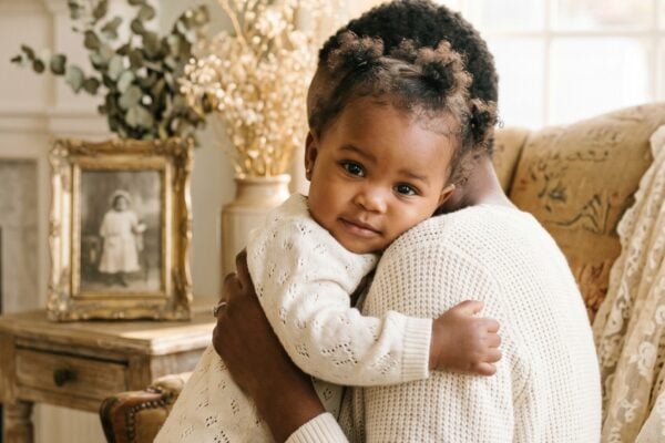 Baby Girl in a sun-filled living room with heirloom furniture and soft lace — 200+ Saint Names for Girls — Classic Faith, Timeless Beauty