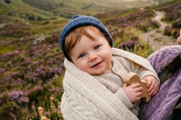 Baby Boy in a misty Scottish highland valley dotted with native purple heather — 200+ Scottish Baby Boy Names With Rugged Celtic Character