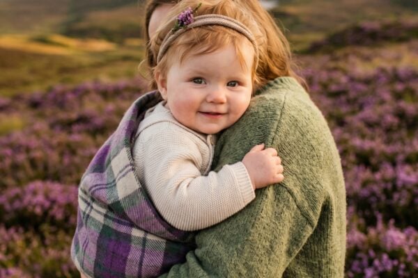 Baby Girl in an open Scottish moorland with purple heather, soft golden light — 200+ Scottish Baby Girl Names Full of Highland Magic