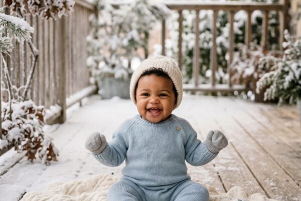 Baby in a snow-dusted outdoor porch with soft morning light — Snow Baby Names Soft as First Snowfall