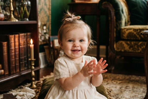 Baby Girl in a moody parlor with deep jewel-tones and ornate vintage furnishings — 200+ Southern Gothic Baby Names With Dark Charm and Romance