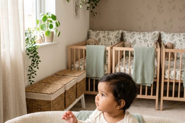 Baby in a bright nursery with three coordinated cribs and botanical accents — Triplet Baby Names With Coordinated Charm