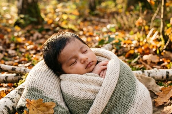 Baby in A forest edge with dappled golden light and autumn foliage — Wildwood Baby Names That Feel Like a Forest Walk