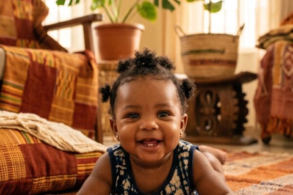 Baby Girl in a sun-filled room with Yoruba woven textiles and warm earth tones — 200+ Yoruba Baby Names Full of Meaning and Cultural Pride