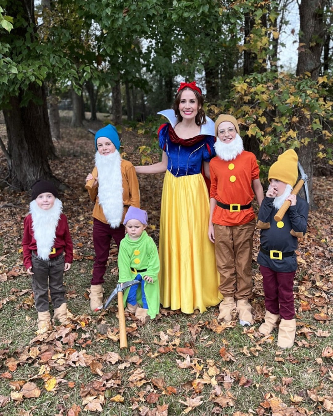 A family dressed as Snow White and several of the seven dwarfs with knit caps, homemade beards, and coordinated tunics.