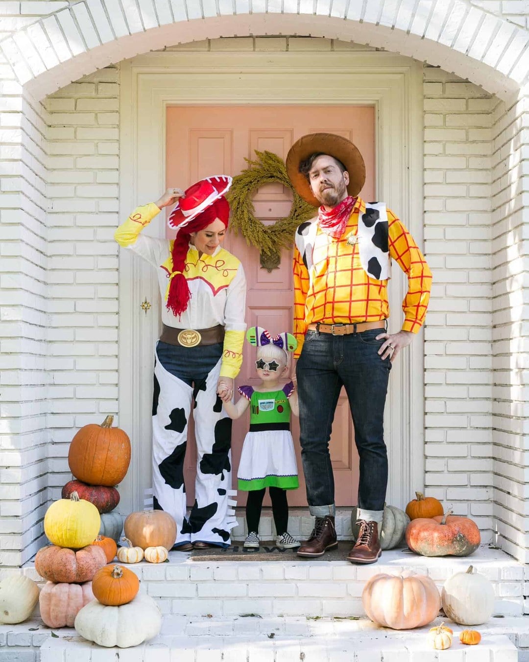 Family dressed as the Toy Story gang, including Woody with a felt vest and sheriff's badge, Jessie in a hand-painted yellow-and-red shirt, and Buzz Lightyear