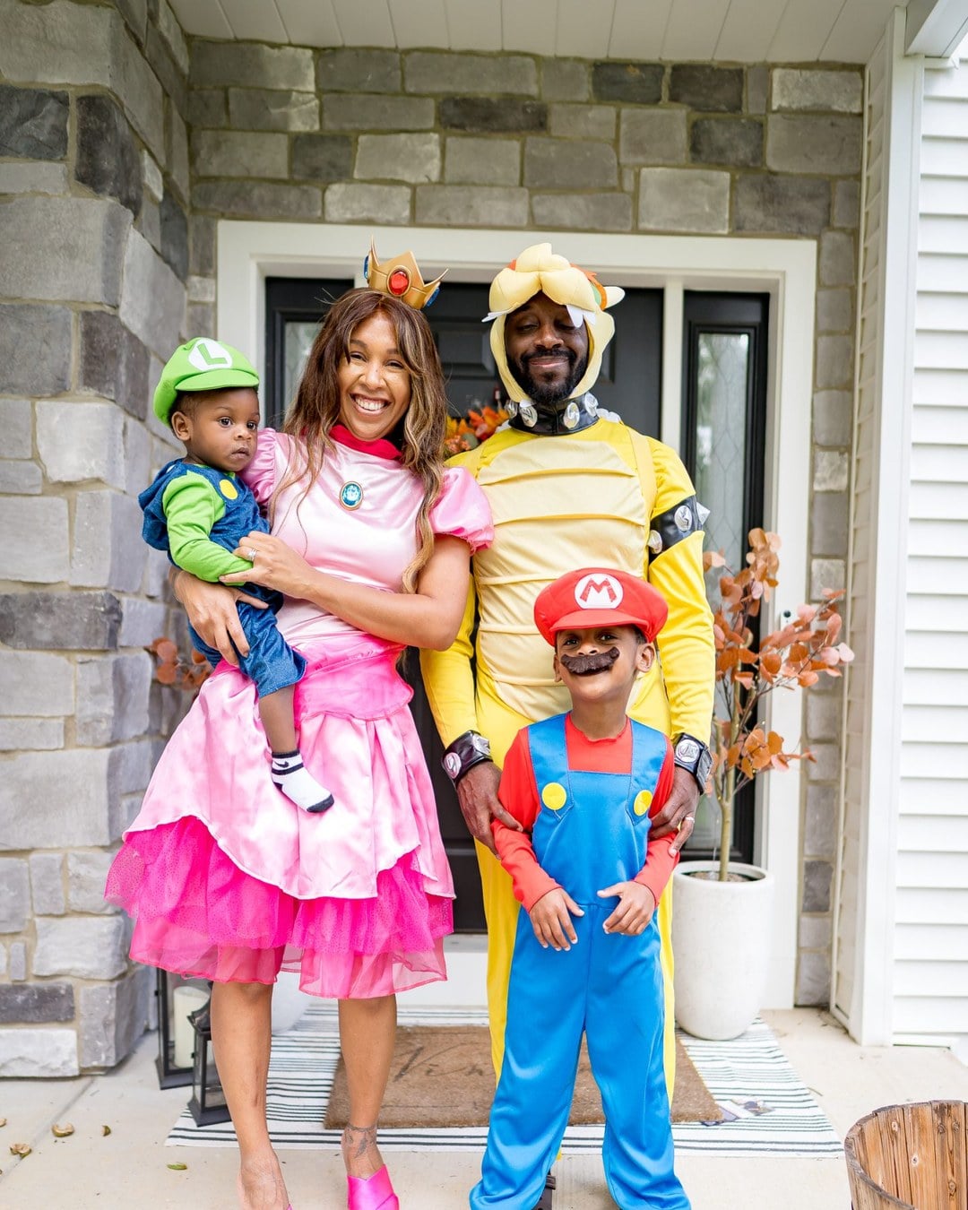 Family dressed as Super Mario Bros. characters with Mom as Princess Peach, Dad as Bowser, and two sons as Mario and Luigi