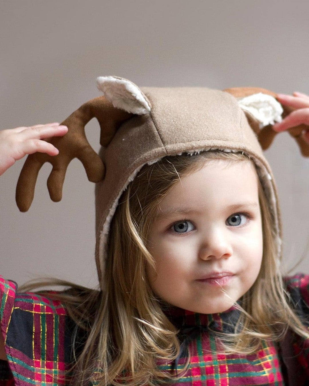 Toddler in a tan fleece hooded bonnet with soft brown fabric antlers and cream sherpa-lined ears