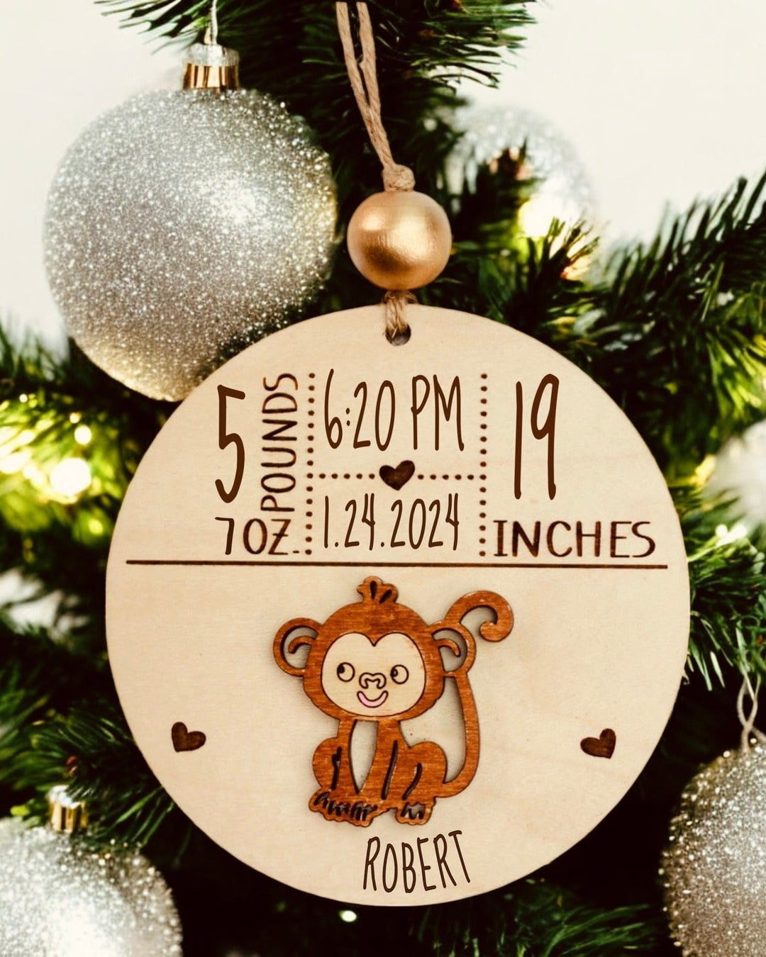 A wooden ornament engraved with a baby's name, birth date, weight and length