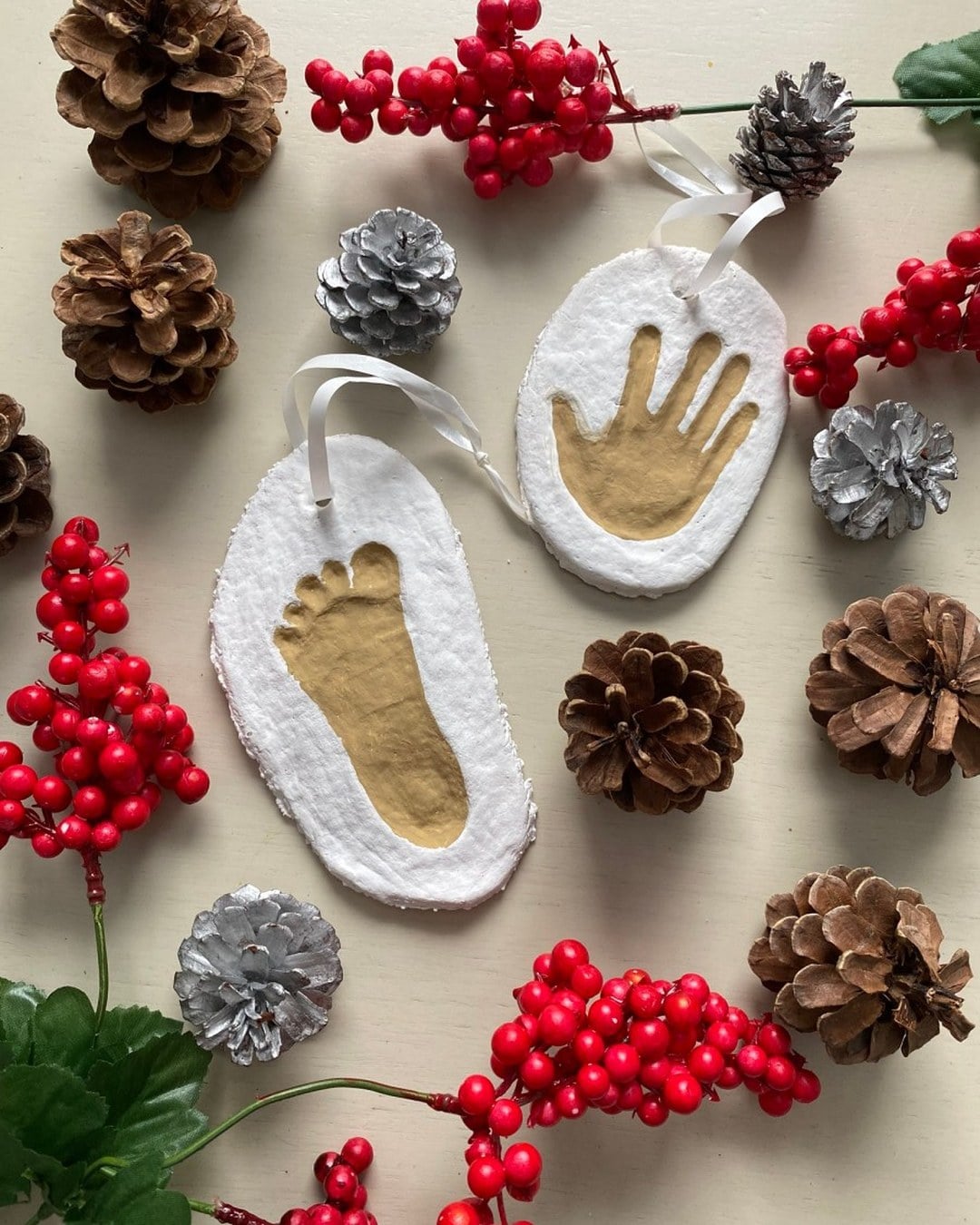 A salt-dough ornament with a baby footprint, painted and tied with a ribbon