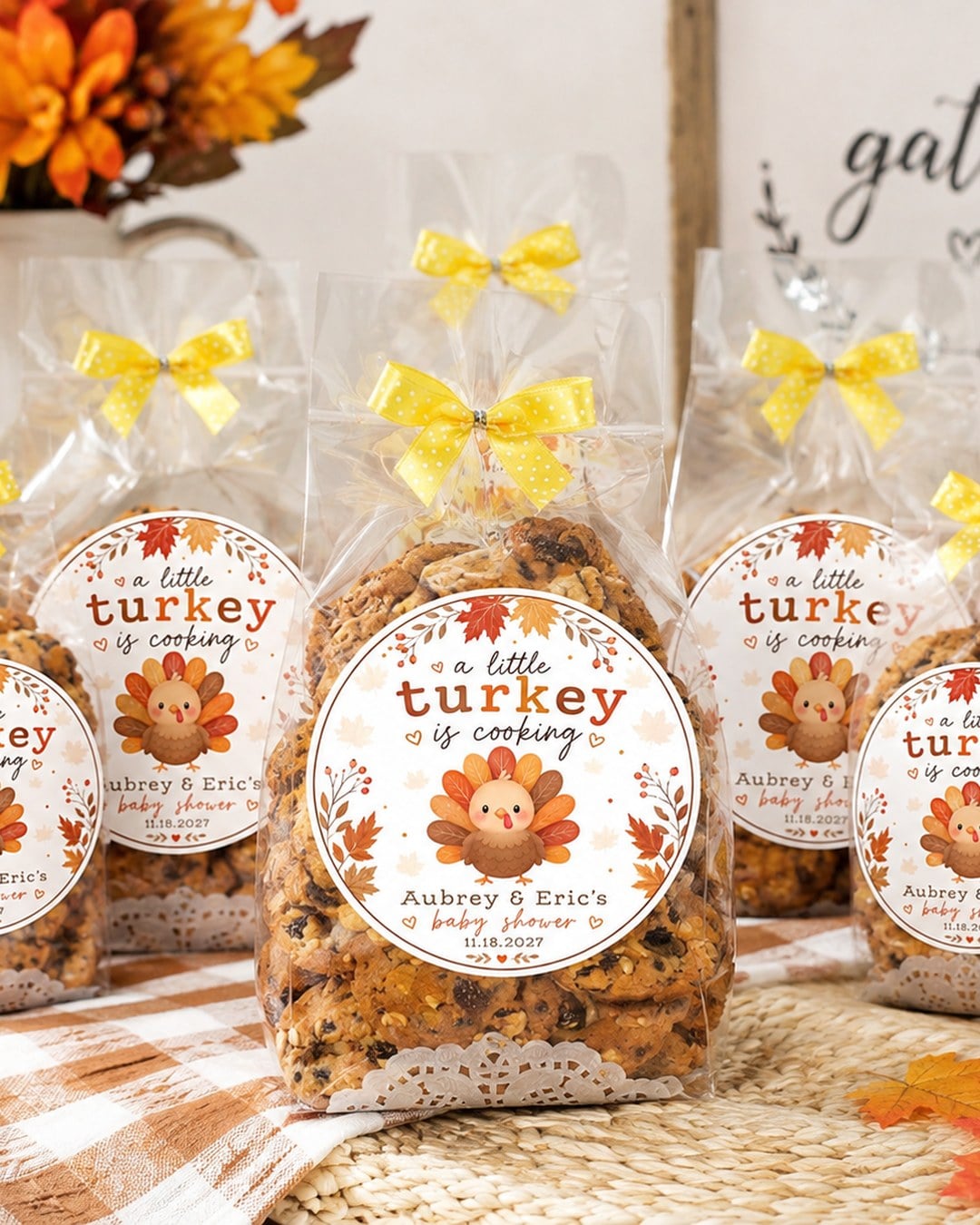 Clear cookie bags tied with yellow bows and round turkey stickers set among pumpkins and maple leaves